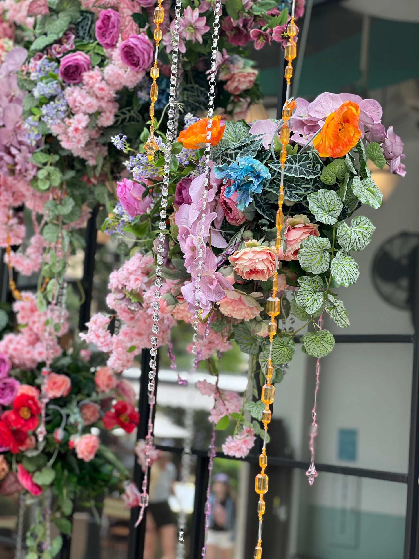multiple types of flowers of different colors, hanging from above