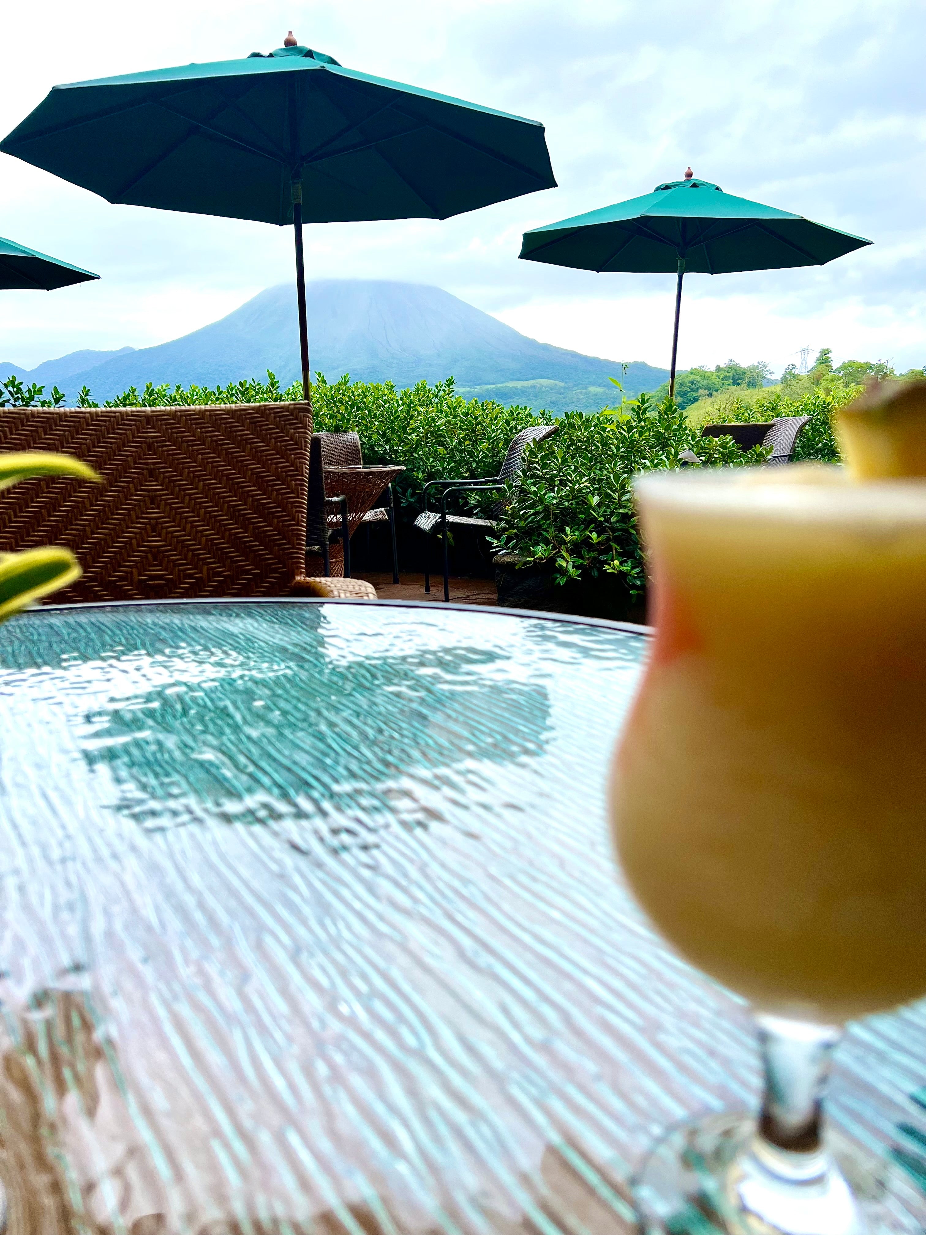 view of Arenal volcano in La Fortuna, Costa Rica from a table with cocktail