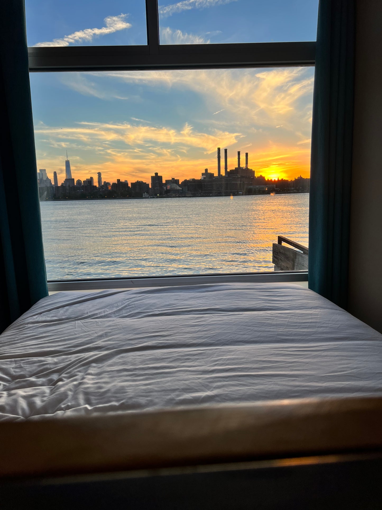 View of the NYC skyline at sunset from a bedroom